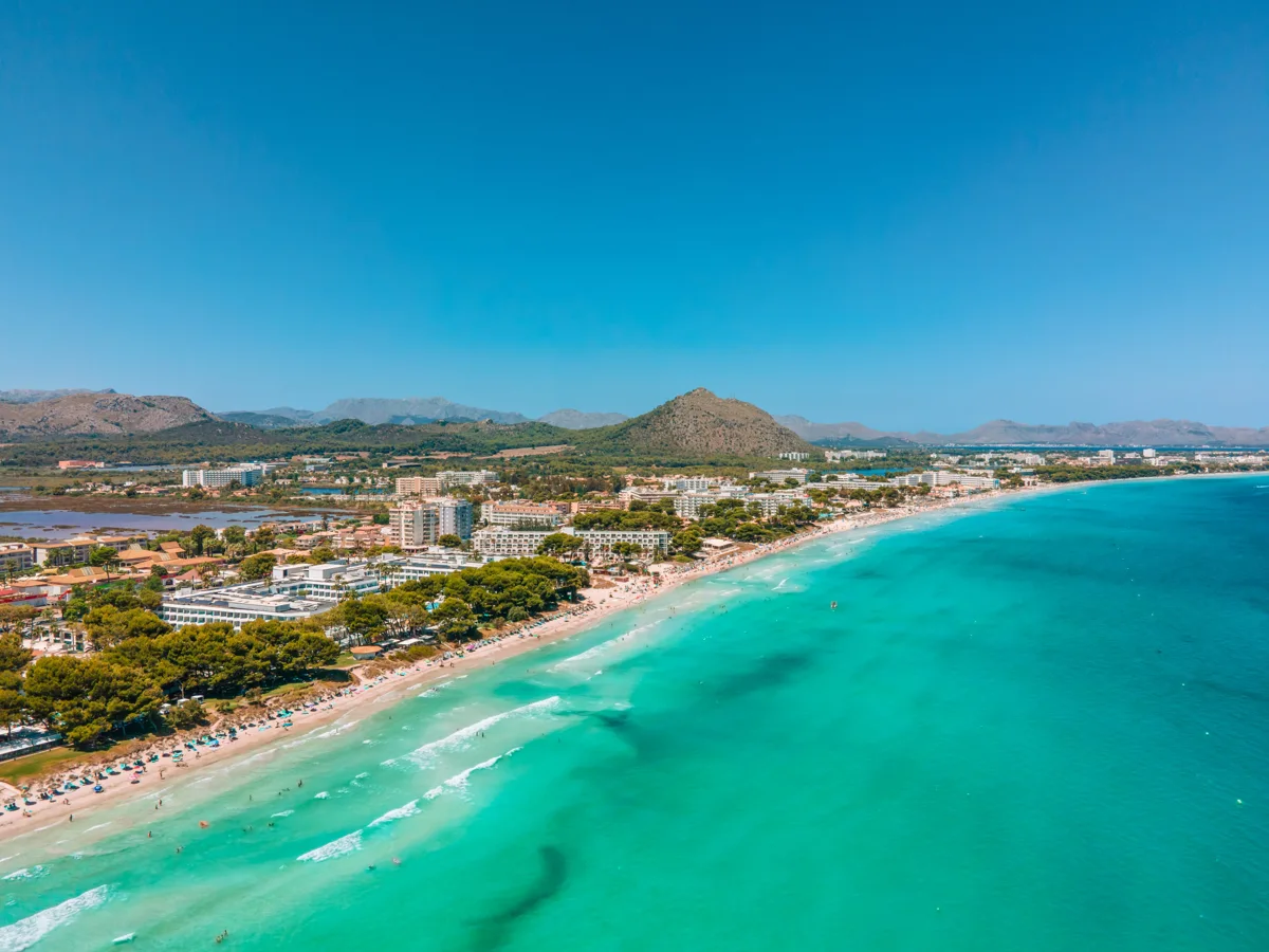 Vista aérea de Playa de Muro con arena, hoteles y bahía turquesa